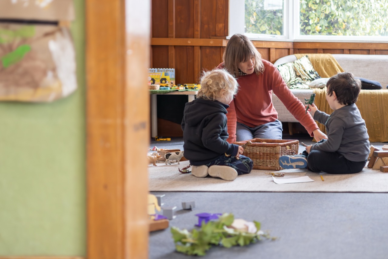 A child holding up their artwork at Waka Huia Childcare
